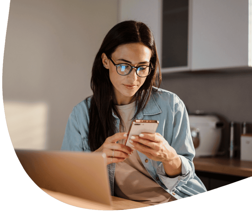 Žena v okuliaroch číta správu na smartfóne.